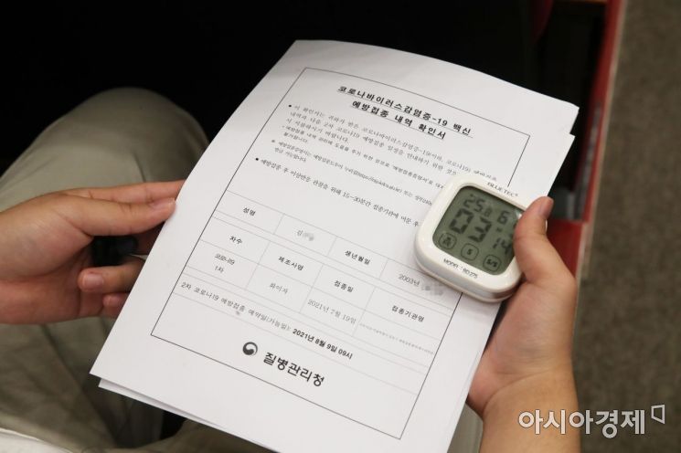 '고3 학생 및 고교 교직원 백신 접종‘이 시작된 19일 서울 양천구 해누리 타운에서 한 고3 학생이 백신 접종 내역 확인서와 스톱워치를 들고 있다. 2021. 7. 19. 사진공동취재단