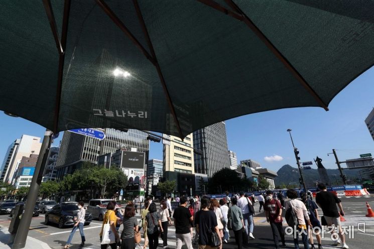 '도심 속 그늘 오아시스' 광화문 사거리에서 시민들이 대형 그늘막 아래 이동하고 있다. /문호남 기자 munonam@