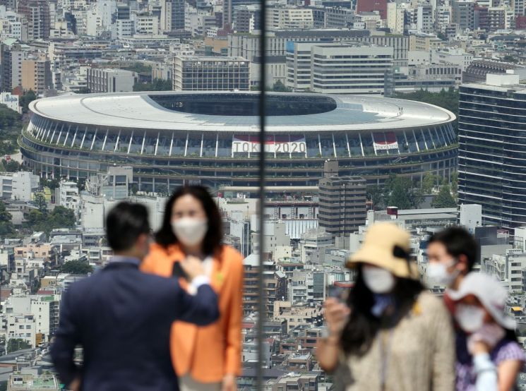 도쿄올림픽 개막식을 이틀 앞둔 21일 오후 일본 도쿄도(東京都)의 한 고층 건물 전망대 방문객들이 도심을 배경으로 기념사진을 찍고 있다. [이미지출처=연합뉴스]