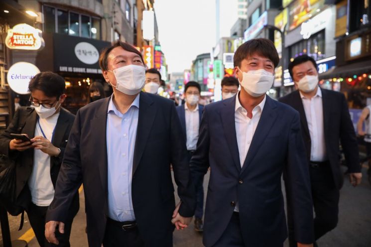 이준석 국민의힘 대표와 윤석열 전 검찰총장이 25일 오후 서울 광진구 건대맛의거리에서 '치맥회동'을 마친 뒤 손을 잡고 걷고 있다. (사진제공=연합뉴스)
