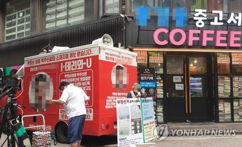 서울 종로구의 한 서점 외벽에 그려진 대권 주자 윤석열 후보의 부인 김건희 씨를 비방하는 내용의 벽화가 논란이 되고 있는 가운데, 29일 오전 보수 성향 단체 회원과 유튜버들이 벽화 앞에서 시위를 하고 있다./사진=연합뉴스