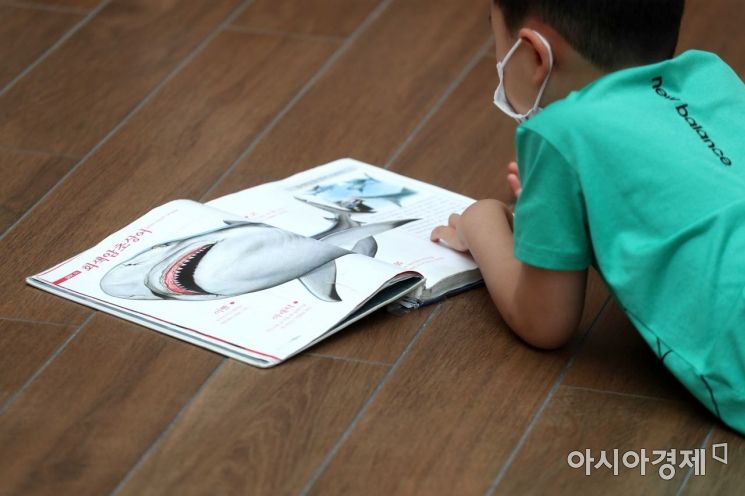 '나는 상어 박사' 한 어린이가 바닥에 앉아 책을 보고 있다. /문호남 기자 munonam@