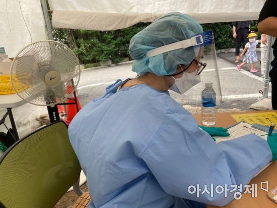 광주광역시 남구보건소 선별진료소에서 온몸을 보호장구로 감싼 의료진이 체감온도가 35도 이상인 날씨에도 불구하고 선풍기 하나에 의지한 채 시민들을 응대하고 있다. 조형주 기자