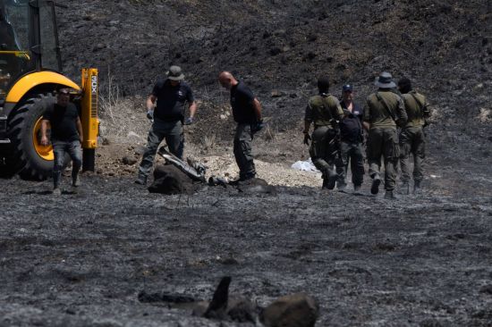 이스라엘 북부 키르야트 시모나에서 이스라엘 보안요원들이 레바논에서 발사된 로켓의 잔해를 살피고 있다.[이미지출처=연합뉴스]