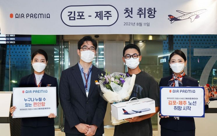 Shim Ju-yeop, CEO of Air Premia (second from left), and the first reservation passenger (third from left) are taking a commemorative photo.