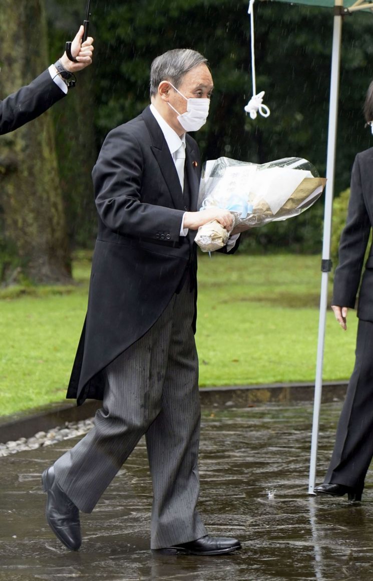 스가 요시히데 일본 총리는 15일 오전 도쿄 지도리가후치에 있는 전몰자묘원에 헌화했다. 사진은 꽃다발을 들고 전몰자묘원으로 향하는 스가 총리. 사진 = 교도/연합뉴스