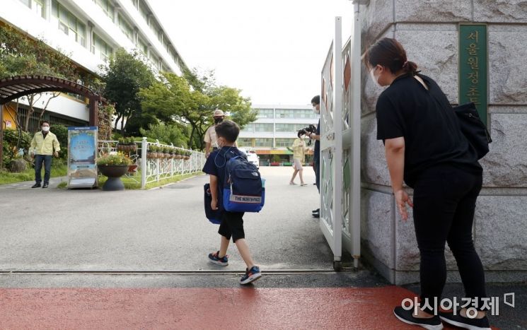 '걱정 가득' 강서구 월정초 정문에서 한 학부모가 등교하는 아들의 뒷모습을 바라보고 있다. /사진공동취재단