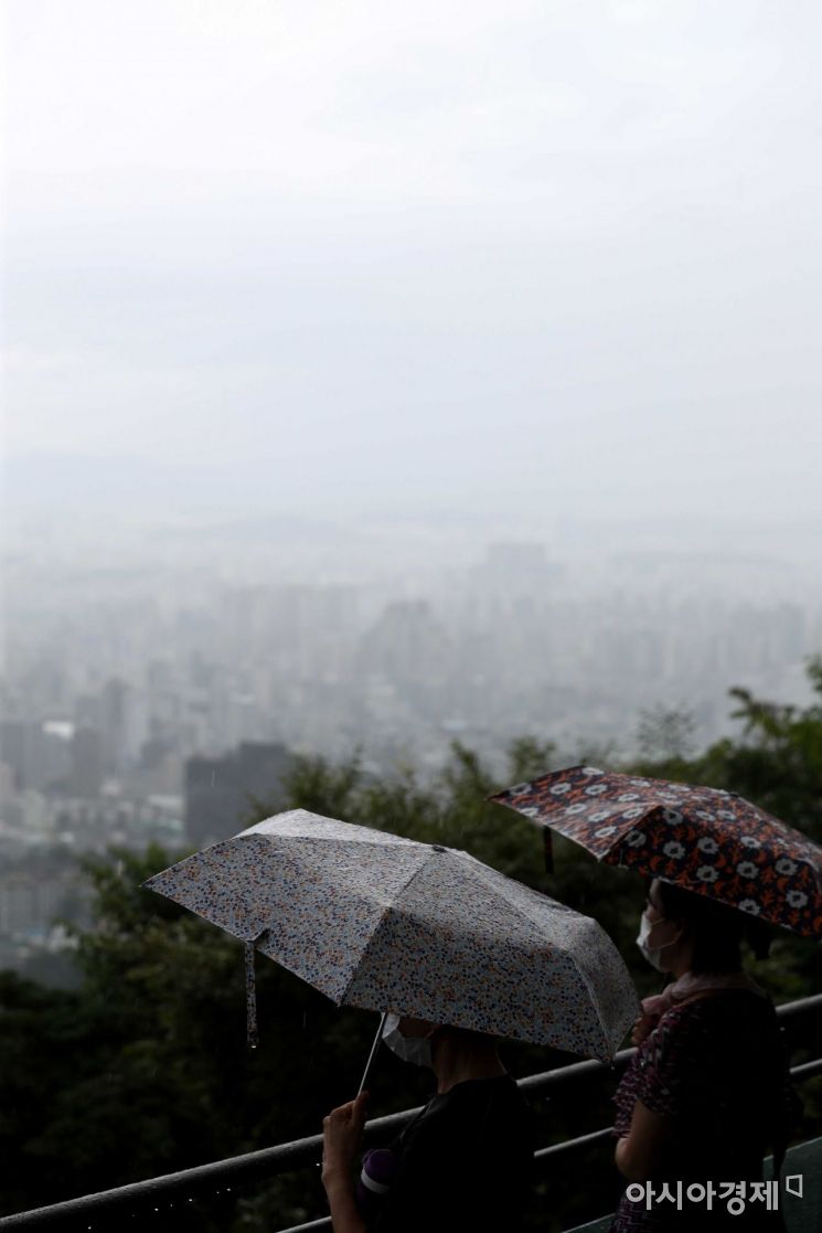 전국에 비가 내린 18일 서울 남산을 찾은 시민들이 비구름과 안개가 내려앉은 도심을 바라보고 있다. /문호남 기자 munonam@