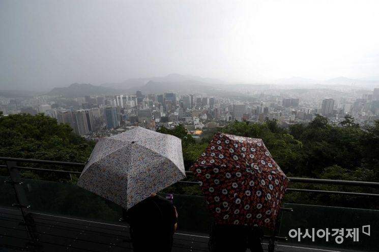 전국에 비가 내린 18일 서울 남산을 찾은 시민들이 비구름과 안개가 내려앉은 도심을 바라보고 있다. /문호남 기자 munonam@