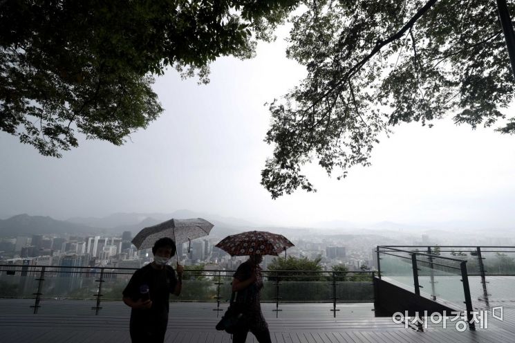 서울 남산을 찾은 시민들이 비구름과 안개가 내려앉은 도심을 바라보고 있다. /문호남 기자 munonam@