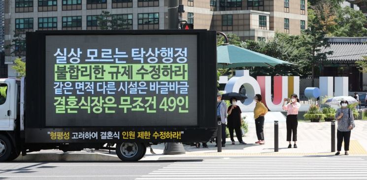 전국신혼부부연합회 소속회원들이 19일 오전 서울시청 앞에서 차량을 이용해 코로나19 방역 관련 '불합리한 결혼식 지침 수정'을 요구하는 비대면 시위를 벌이고 있다. [이미지출처=연합뉴스]
