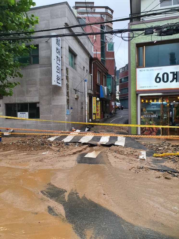 24일 부산 연제구 도로가 밤새 내린 폭우로 파손돼 교통이 통제되고 있다. [이미지출처=부산경찰청]