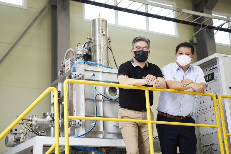 초고순도 몰리브덴 정련 장비 앞에 서 있는 한국생산기술연구원 박경태 박사(오른쪽)와 ㈜엔에이티엠 김인호 대표.
