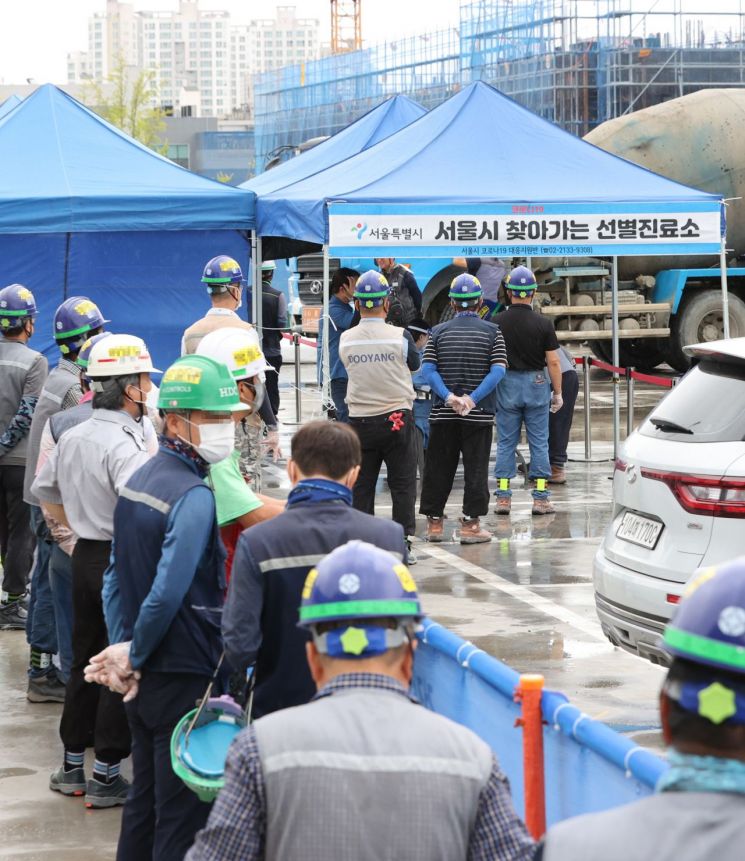 24일 서울 강동구 한 아파트 공사현장에 설치된 선별진료소에서 근로자들이 검사를 받고 있다. [이미지출처=연합뉴스]
