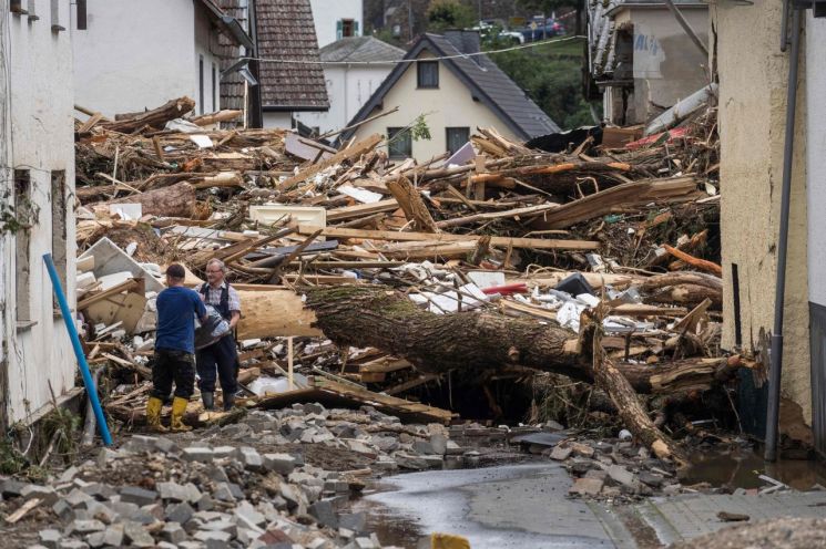 서유럽에 내린 폭우로 홍수가 발생한 독일 서부 슐트에서 지난 15일(현지시간) 이재민들이 무너진 가옥의 잔해 속에서 가재도구를 챙기고 있다. [이미지출처=연합뉴스]