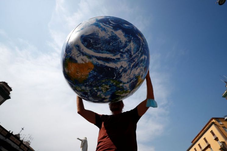 지난달 22일(현지시간) 이탈리아 나폴리에서 주요 20개국(G20) 기후·환경 장관회의가 이틀째 진행 중인 가운데 한 시위 참가자가 지구본 풍선을 들고 기후변화 대응을 촉구하고 있다. [이미지출처=연합뉴스]