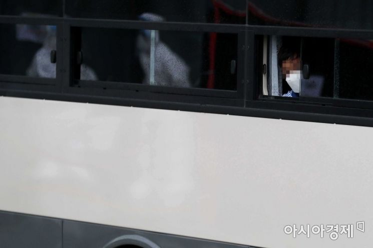 과거 한국을 도운 아프간인을 태운 버스가 27일 경기 김포 마리나베이 호텔에서 충북 진천의 국가공무원 인재개발원으로 이동하고 있다. 한 어린이가 취재진을 바라보고 있다. 창문에 방역복을 입은 시설 관계자가 보인다. /문호남 기자 munonam@