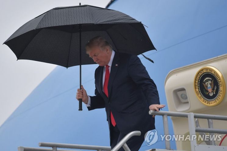미국 대통령 전용기 '에어포스 원'에서 나오고 있는 도널드 트럼프 전 대통령이 손에 검은 우산을 쥐고 있다. / 사진=연합뉴스