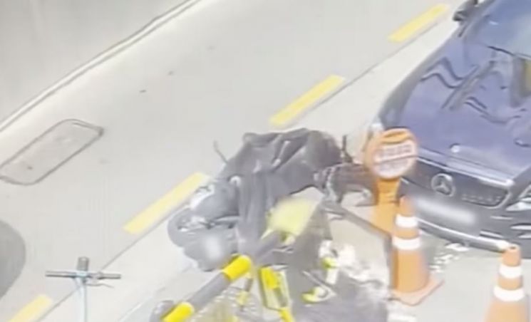 주차장을 빠져나가던 한 운전자가 주차장에 세워진 배달용 오토바이를 손으로 밀어 넘어뜨려 오토바이의 배달용 보관함에 담겨 있던 음식들이 우르르 쏟아져 나왔다. [사진= 유튜브 '한문철TV']