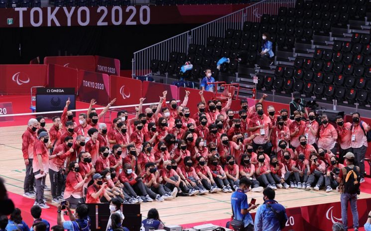 5일 오후 일본 도쿄 요요기 국립경기장에서 열린 2020 도쿄 패럴림픽 배드민턴 남자 복식(WH2) 시상식이 끝난 뒤 자원봉사자와 관계자들이 기념촬영을 하고 있다. [이미지출처=연합뉴스]