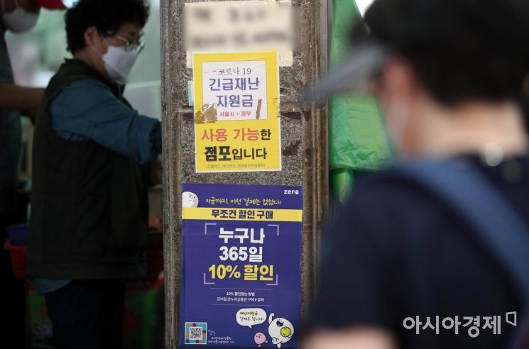 코로나19 상생 국민지원금(재난지원금) 지급 절차가 시작된 지난 6일 서울 마포구 재래시장의 한 가게에 긴급재난지원금 사용 가능 안내 문구가 붙어있다./김현민 기자 kimhyun81@