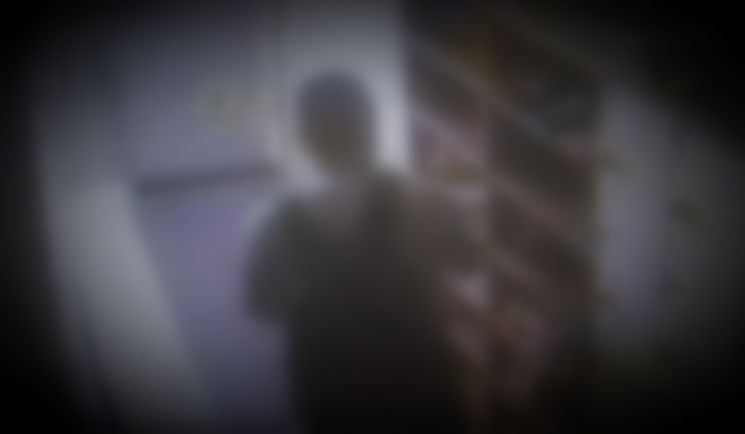 여성 전용 고시텔의 신발장에서 신발을 빼 냄새를 맡고 있는 한 남성. [이미지출처=고시텔CCTV,부산경찰]