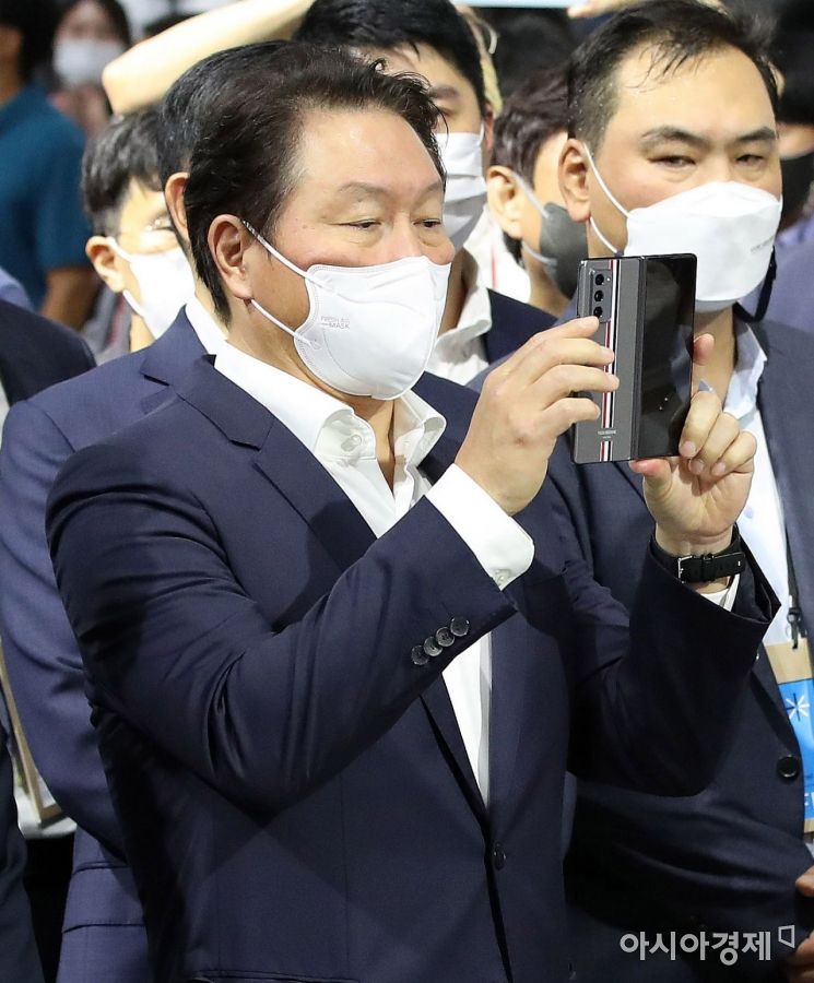 최태원 SK그룹 회장이 지난 9월 경기 고양시 킨텍스에서 열린 '2021 수소모빌리티+쇼' 현대자동차 부스에서 재난현장에서 화재를 진압할 수 있는 레스큐 드론을 휴대폰으로 촬영하고 있다./고양=강진형 기자aymsdream@