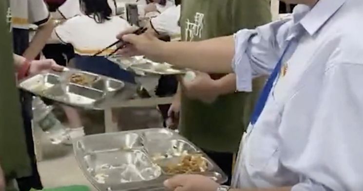 중국의 한 중학교 교장이 학생들의 '음식을 남기는 습관'을 고치려고 학생들이 먹고 남긴 반찬을 먹었다. [사진=바이두 캡처]