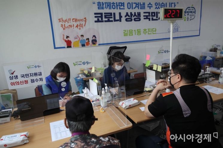 코로나19 상생 국민지원금 오프라인 신청 첫날인 13일 서울 성북구 길음1동 주민센터에서 시민들이 관련 상담을 받고 있다. /문호남 기자 munonam@