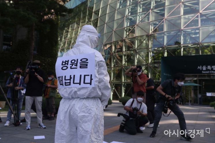 의료진이 사직서를 공중에 흩뿌린 뒤 시청을 향해 인사하고 있다. /문호남 기자 munonam@