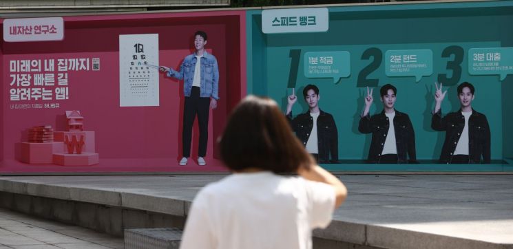 지난달 20일 서울시내 한 은행에 내걸린 대출 등 은행 금융상품 광고판 앞을 한 시민이 지나고 있다. / 사진=연합뉴스