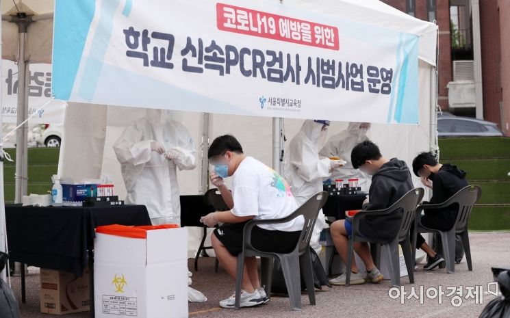 28일 오전 서울 종로구 동성고등학교에서 학생들이 등교하며 코로나19 '신속 자가분자진단 유전자증폭(신속 PCR)' 검사를 받고 있다./사진공동취재단