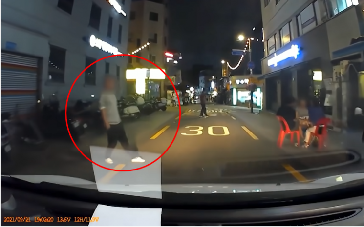 한 남성이 서행하는 차량을 향해 의도적으로 발을 내밀고 있다. 사진=유튜브 채널 '한문철TV' 화면 캡처.