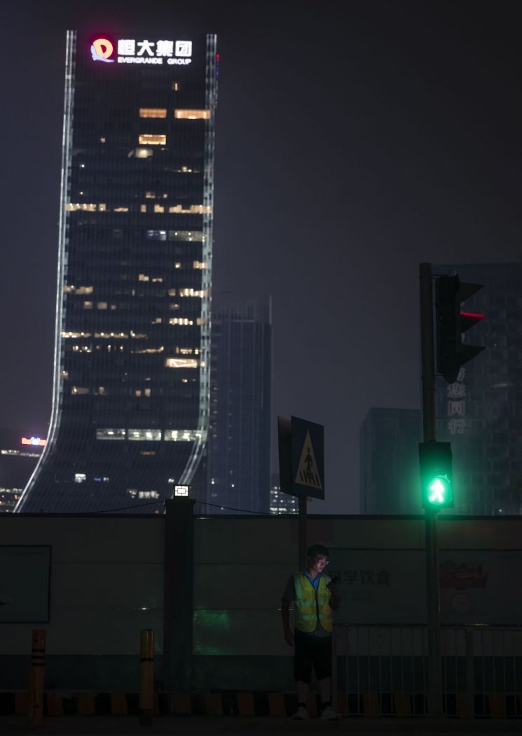 지난달 3O일 중국 대형 민간 부동산 개발업체 헝다 그룹의 광둥선 선전 본사 앞 도로에 한 남자가 서 있다. [이미지출처=연합뉴스]