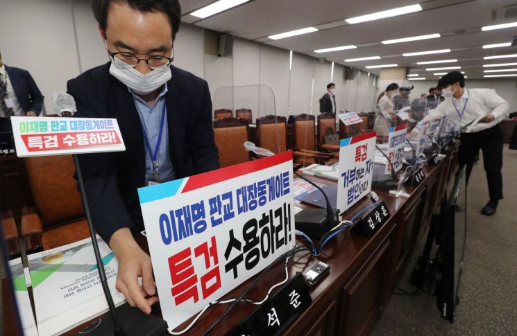 5일 오전 세종시 정부세종청사에서 열린 국회 국토교통위원회의 국토교통부, 행정중심복합도시건설청, 새만금개발청 국정감사에서 국민의힘 관계자들이 대장동 의혹 관련 팻말을 소속 위원석에 붙이고 있다. [이미지출처=연합뉴스]