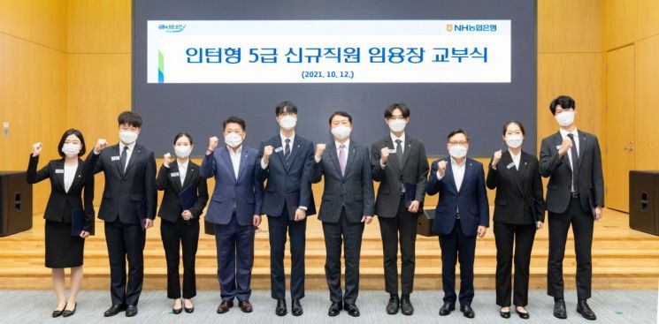 12일 서울 중구 농협은행 본사에서 권준학 은행장 (오른쪽에서 5번째)과 김용택 노조위원장 (왼쪽에서 4번째), 임동순 HR·업무지원부문 부행장 (오른쪽에서 3번째)이 신규 직원들과 함께 임용장 교부식을 마치고 기념사진을 촬영하고 있다.