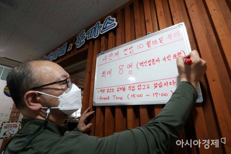 정부가 오는 18일부터 현행 사회적 거리두기 체계를 2주간 유지하고 사적모임 제한 기준을 수도권 최대 8명, 비수도권 최대 10명까지 완화한다고 15일 발표했다. 이날 서울 종로구 한 식당에서 식당 주인이 거리두기 관련 내용을 적고 있다. /문호남 기자 munonam@