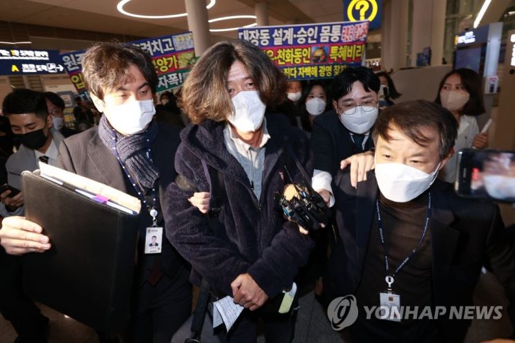 18일 새벽 인천국제공항을 통해 귀국한 남욱 변호사(가운데)가  검찰에 체포된 채 공항 밖으로 빠져나가고 있다. [이미지출처=연합뉴스]
