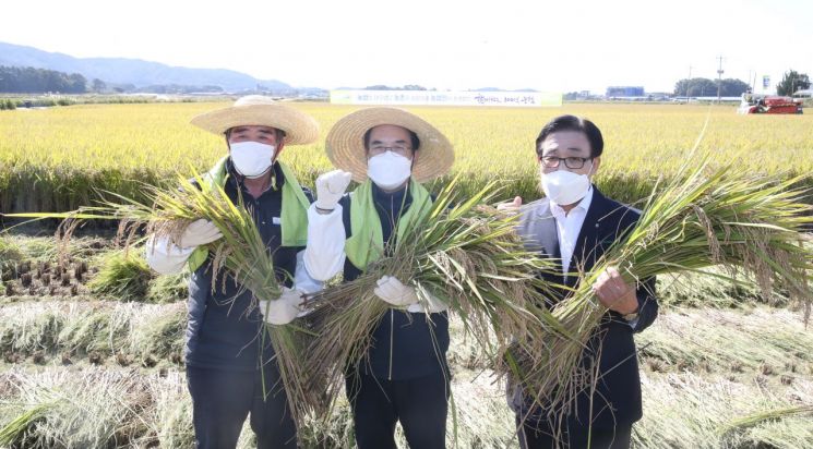 이성희 농협중앙회장(가운데)이 18일 충청남도 보령시에서 벼 수확 시연을 하는 모습.(사진제공=농협)