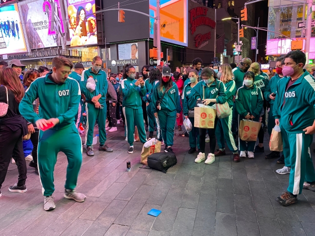 26일(현지 시각) 뉴욕 타임스퀘어에서 '오징어 게임과 함께하는 뉴욕 속 한국여행' 행사 참가자들이 딱지치기를 하고 있다. /사진=연합뉴스