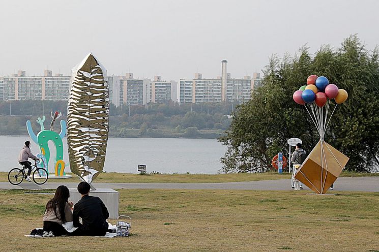시민들이 한강공원에서 조각 작품을 구경하고 있다.
