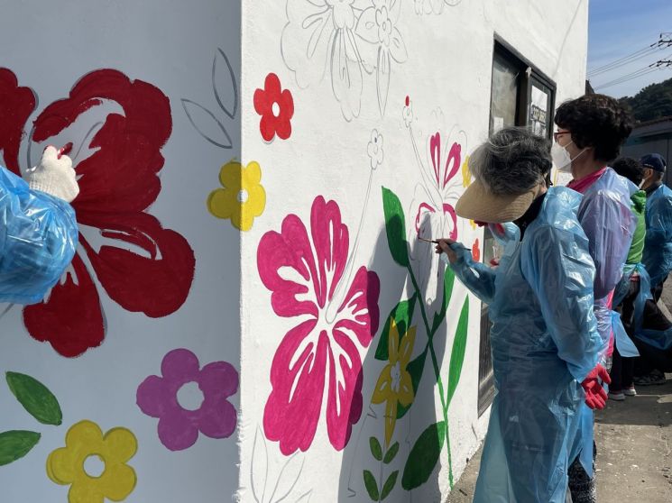 경남 김해시 자원봉사자들이 마을 주민과 함께 '기억채움 마을' 주촌면 양동마을에 벽화를 그리고 있다.