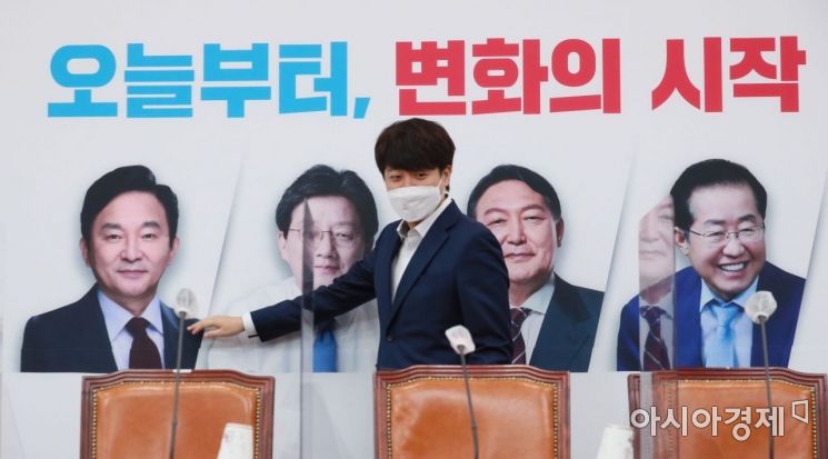 이준석 국민의힘 대표가 1일 국회에서 열린 최고위원회의에 참석하면서 배경판에 나온 대선 경선 후보자들의 얼굴을 살펴보고 있다./윤동주 기자 doso7@