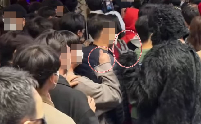 고릴라 분장을 한 남성이 여성의 신체를 몰래 촬영한 뒤 옆에 있던 남성에게 '오케이(OK)' 신호를 보내고 있다. 사진=유튜브 화면 캡처.