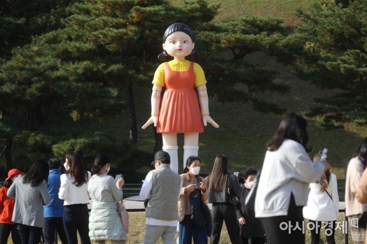 2일 시민들이 서울 송파구 올림픽공원 88잔디마당에 설치된 넷플릭스 드라마 ‘오징어게임’ 속 술래 로봇 영희를 보고 있다. 오징어게임은 지난 9월 17일 공개 이후 넷플릭스가 서비스되는 83개 국가에서 1위에 오르며 세계적인 인기를 얻고 있다. /문호남 기자 munonam@