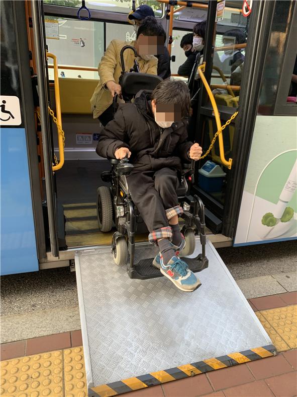 성구씨가 활동지원사의 도움을 받아 저상버스에서 내리고 있다./사진=차현진 인턴기자