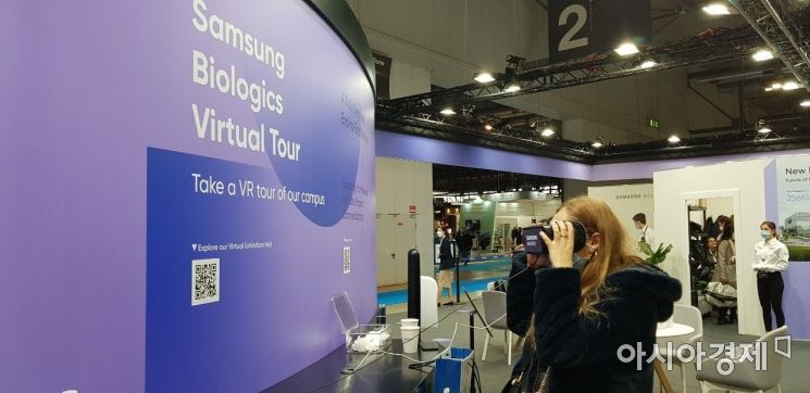 외국인 관람객이 삼성바이오로직스 부스에 설치된 가상현실(VR)안경을 통해 인천 송도 3공장 내부를 바라보고 있다.