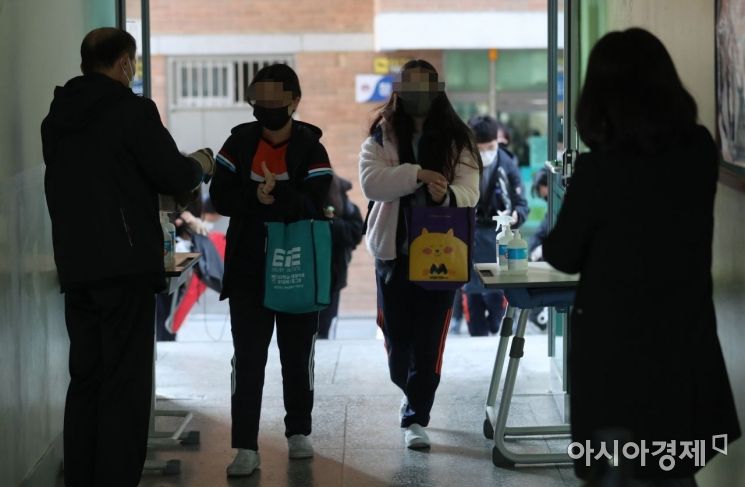 전국 초·중·고교 전면등교가 실시된 22일 오전 서울 한 중학교 학생들이 등교를 하며 손소독제를 바르고 있다./사진공동취재단