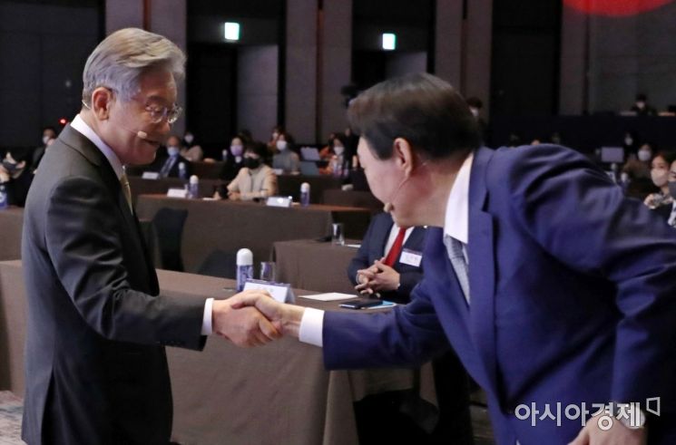 이재명 더불어민주당 대선후보와 윤석열 국민의힘 대선후보가 22일 서울 광진구 그랜드워커힐서울에서 열린 한 행사에 참석, 인사를 나누고 있다./국회사진기자단