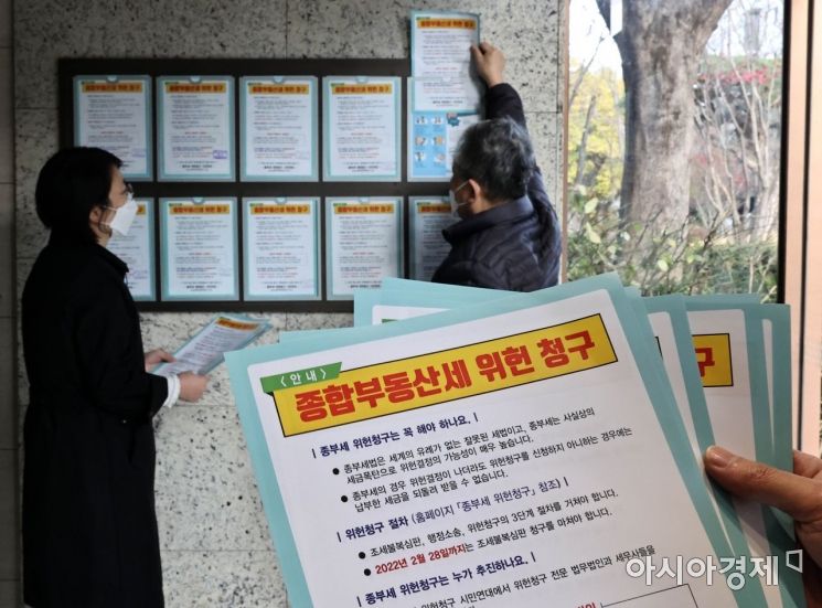 종부세위헌청구시민연대 소속 관계자들이 22일 서울 서초구 한 아파트에서 종합부동산세 위헌청구 안내문을 부착하고 있다./강진형 기자aymsdream@